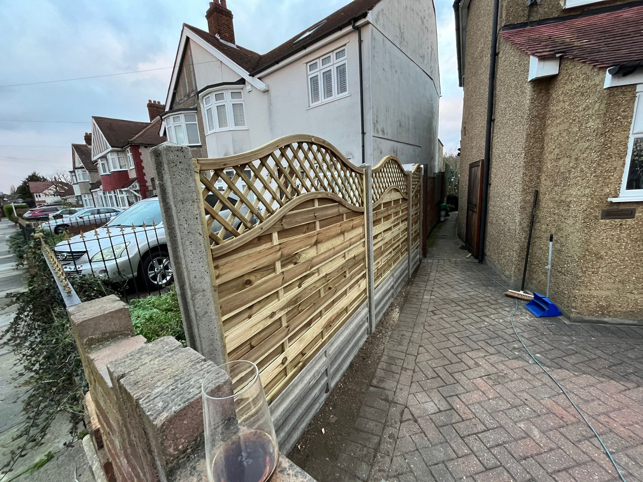 Decorative fence panels with arched lattice tops along a front path.