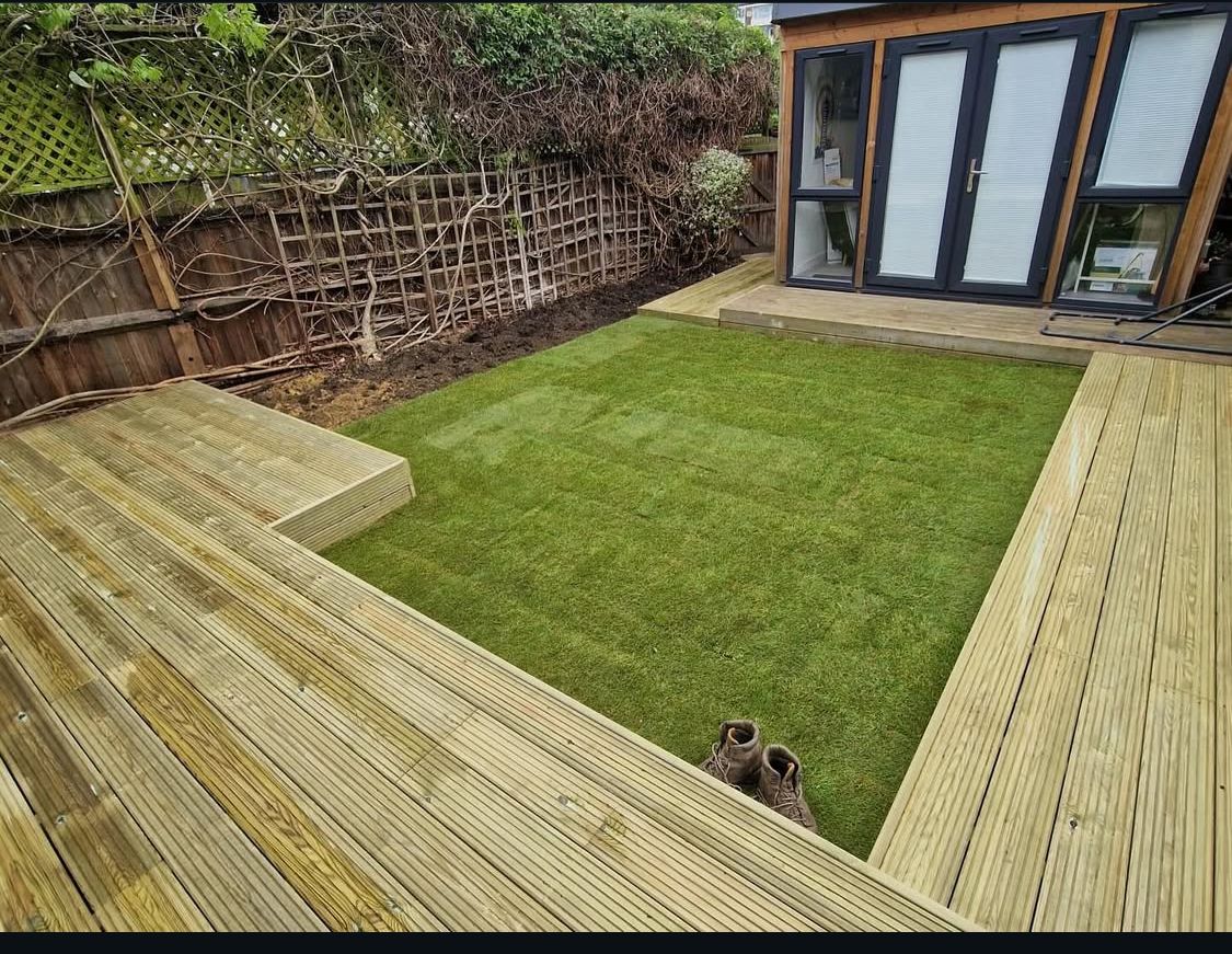 Garden under construction with plank-style paving, gravel and circular lawn area.